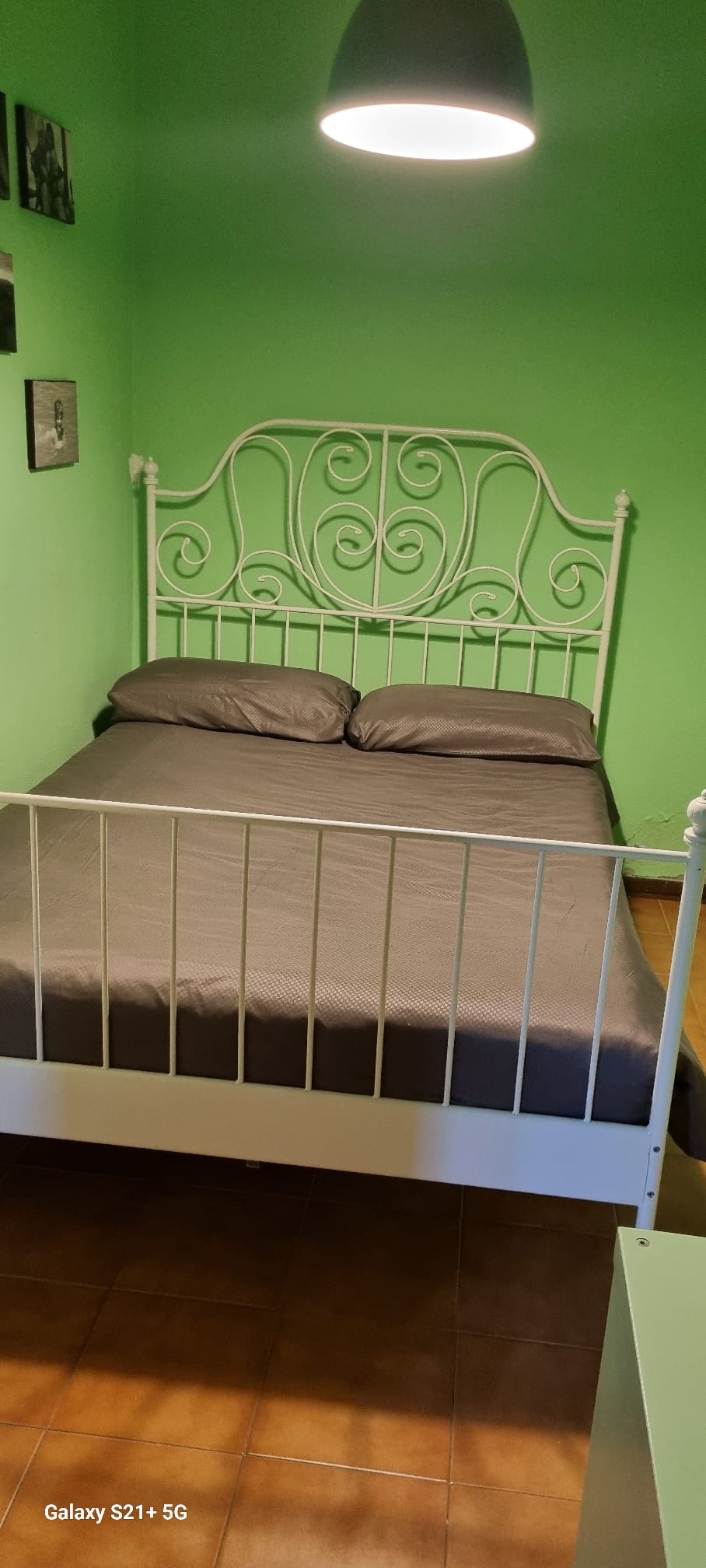 Groene slaapkamer met metalen bed